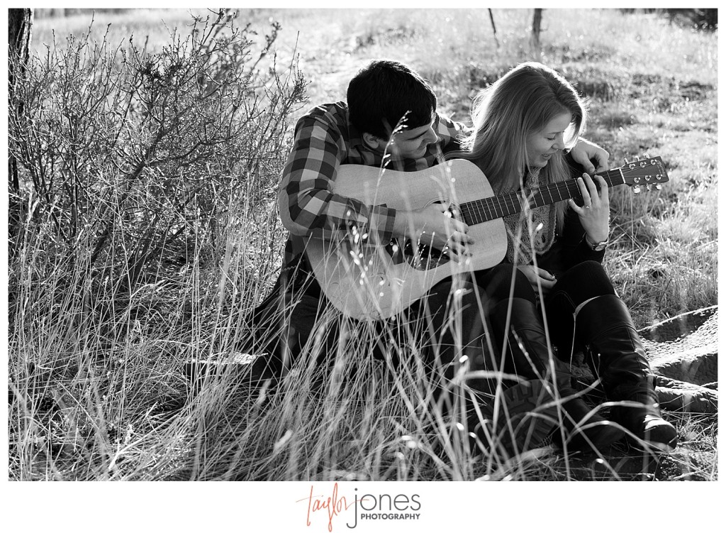 Couple at engagement shoot kissing with guitar