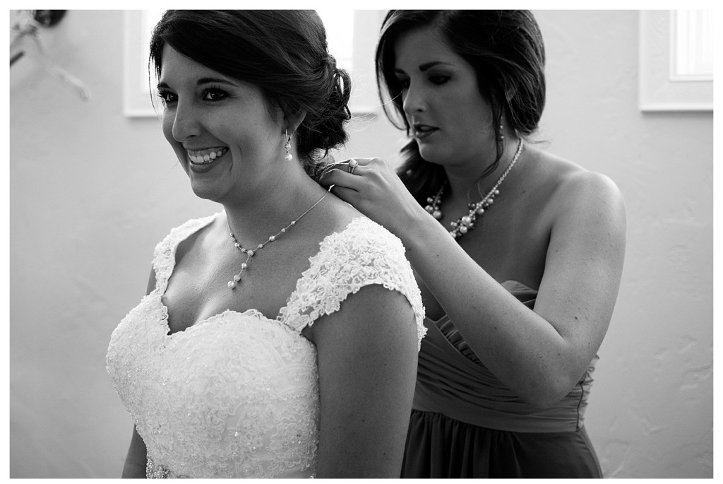 Bride putting on necklace at Baldoria on the water wedding Denver Colorado